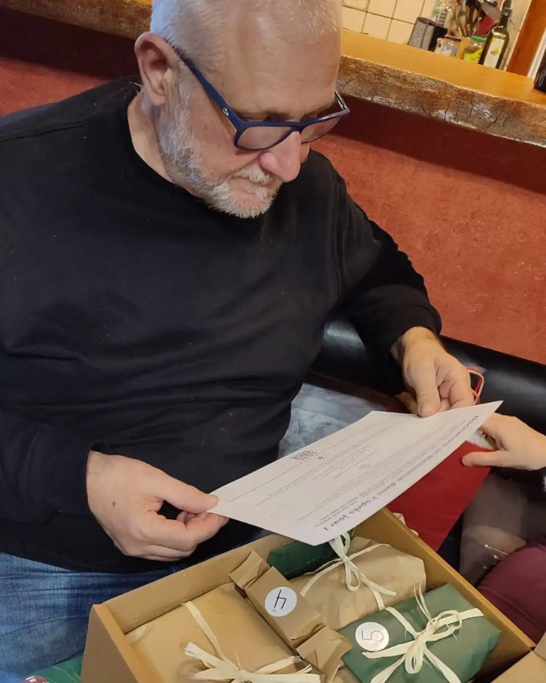 homme ouvrant un calendrier de l'Après Noël Jour K