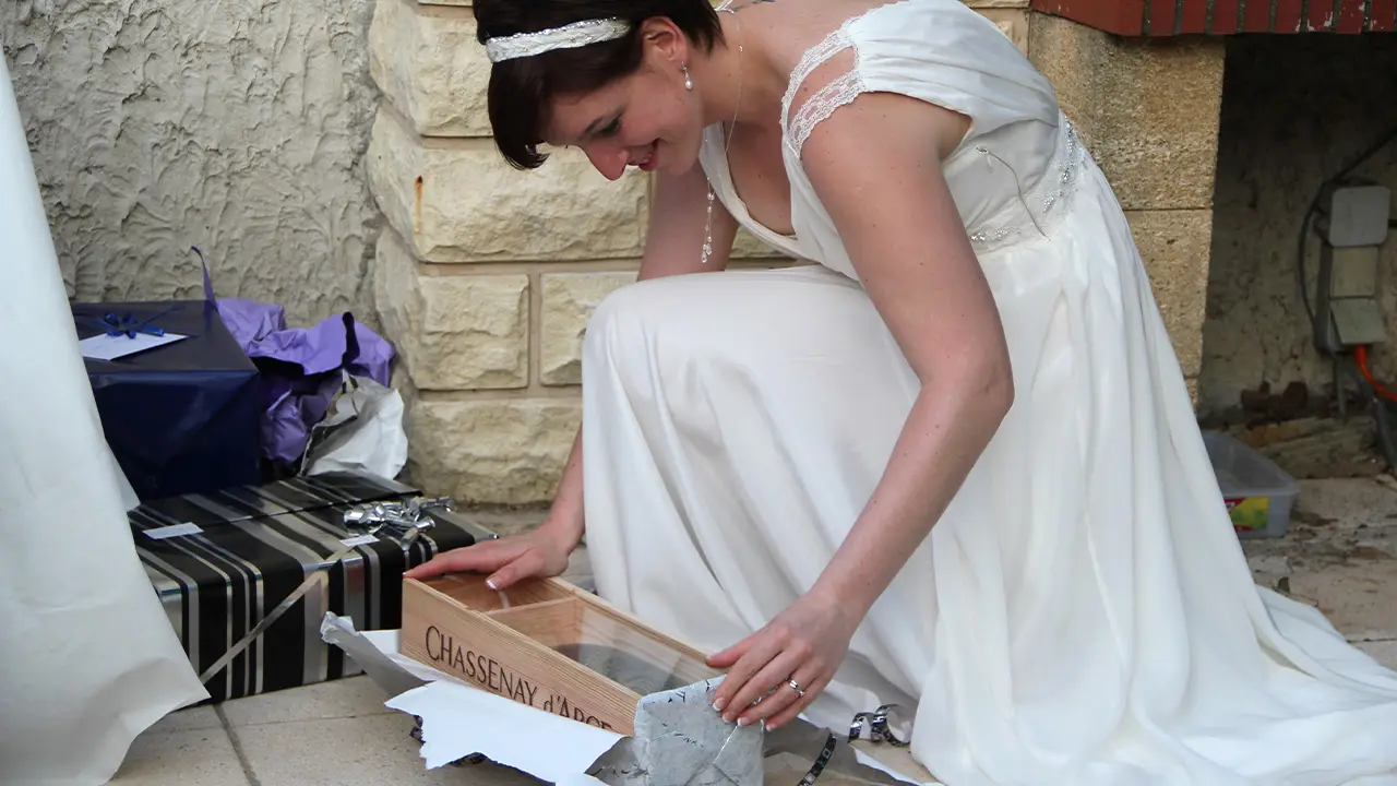 Un cadeau original reçu le jour de notre mariage mariée ouvrant un cadeau de mariage original