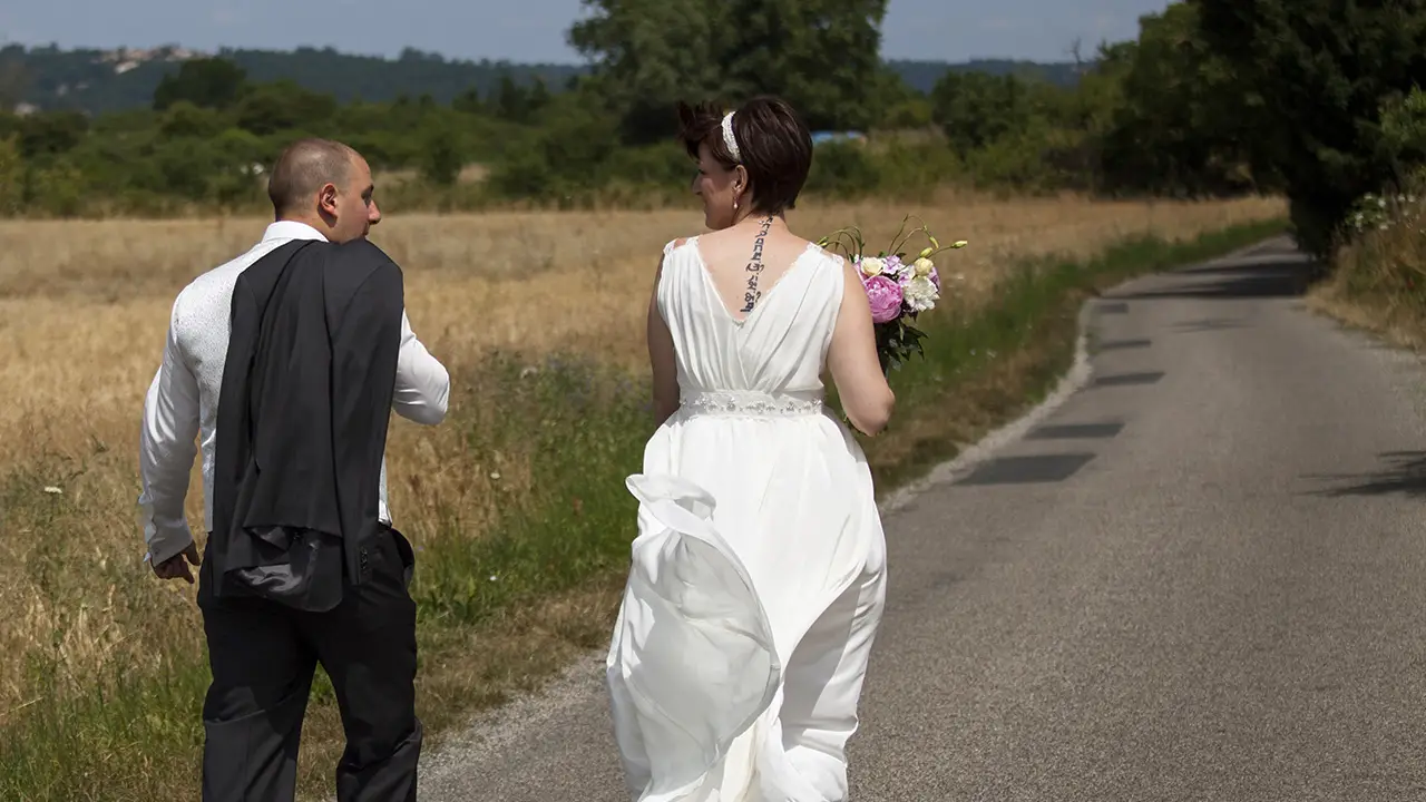En route vers une nouvelle vie commune un couple de jeunes mariés marche sur une route de campagne après la cérémonie