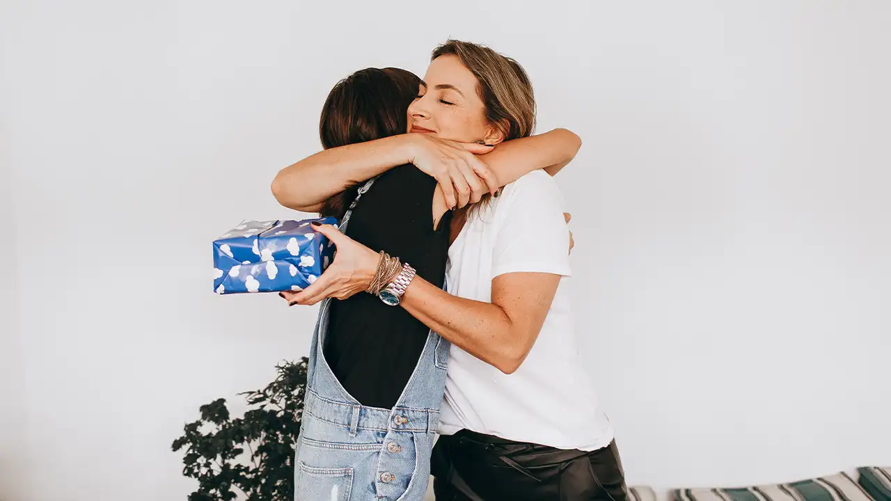 Deux sœurs qui s'embrassent lors d'un échange de cadeau — idées cadeaux originaux pour sa sœur