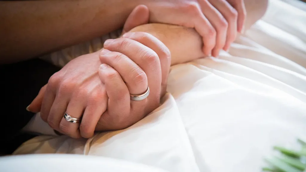 Mains enlacées avec alliances - anniversaire de mariage - symbolique et idées cadeaux